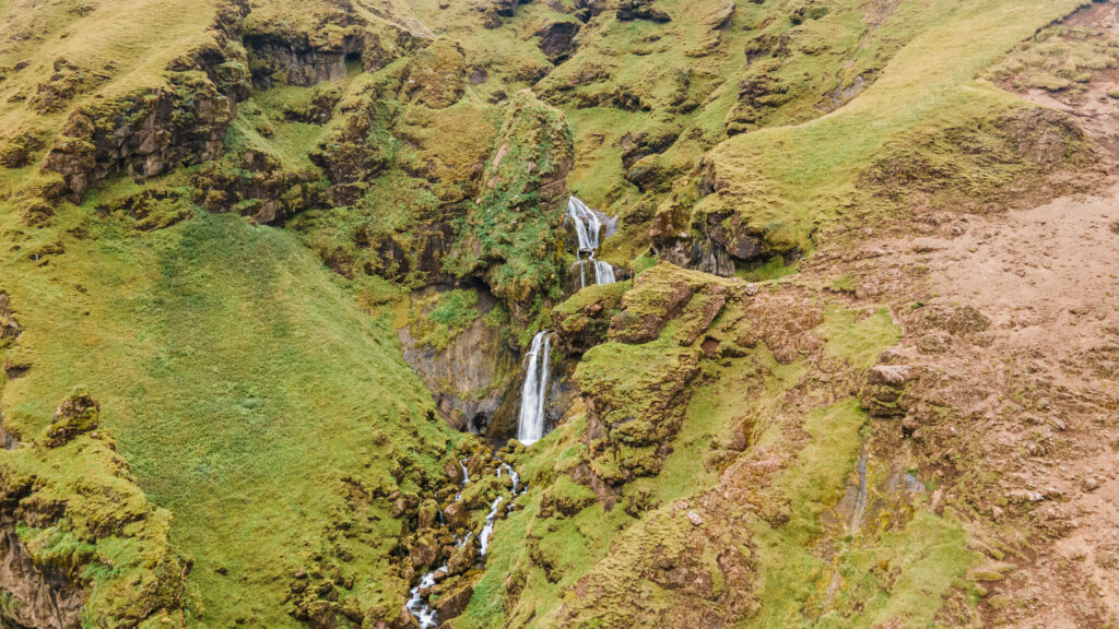 drone photograph of waterfall over cliffs